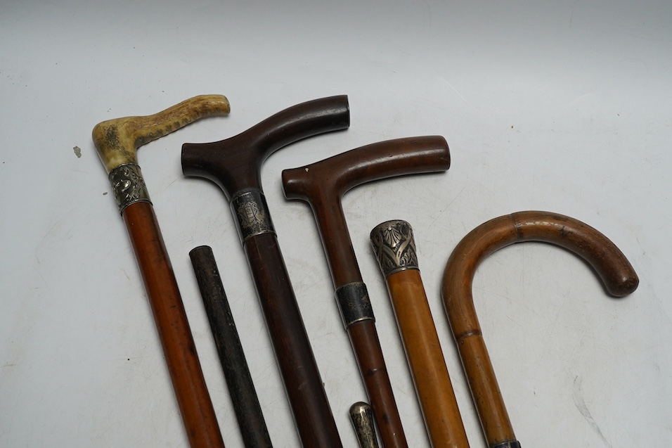 Four mixed silver mounted walking sticks, a riding crop and a baton, longest 88cm. (6). Condition - fair considering use and age